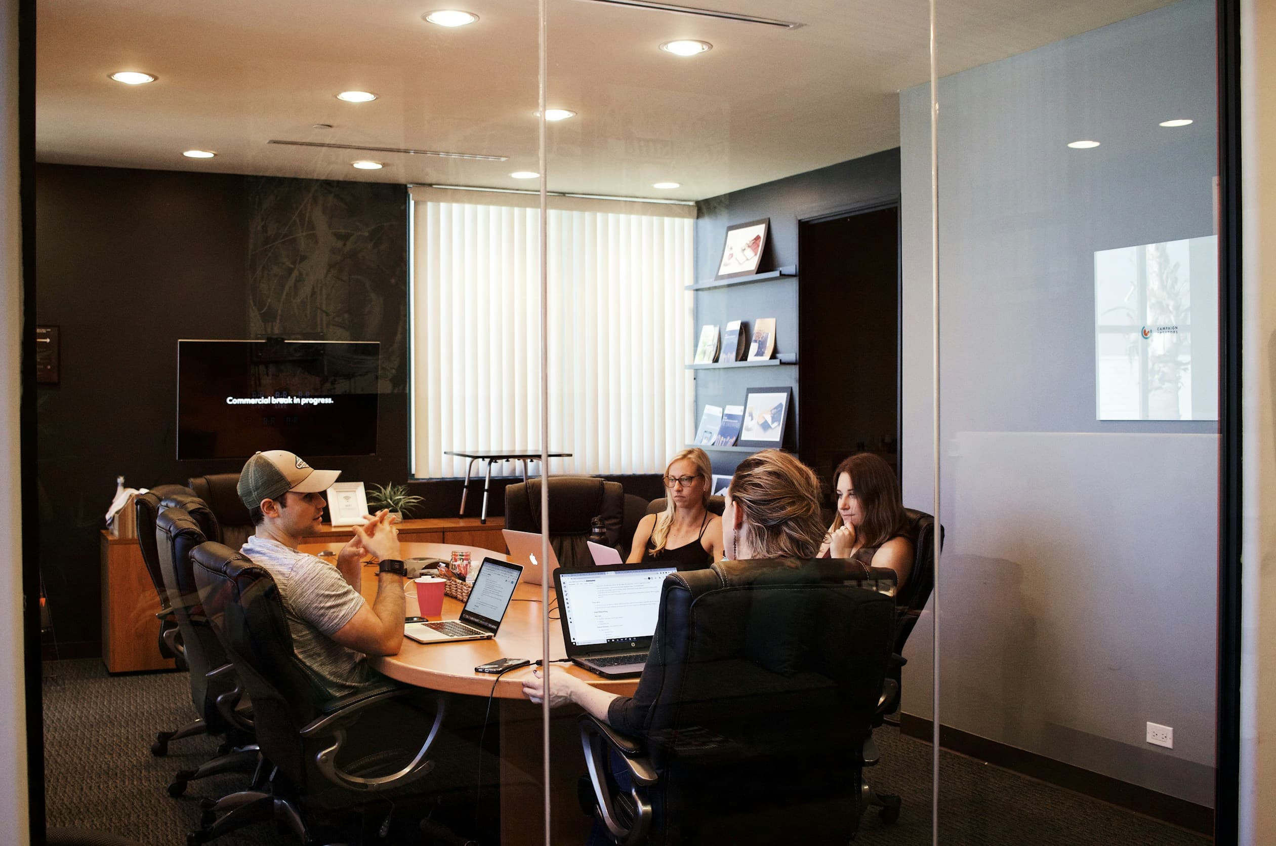 People collaborating in a modern office setting with a laptop and documents on the table in the foreground